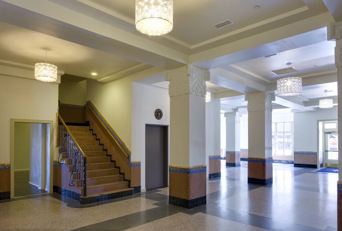 Restored historic lobby at Hotel Clovis Lofts with terrazzo floors, columns, and the original staircase