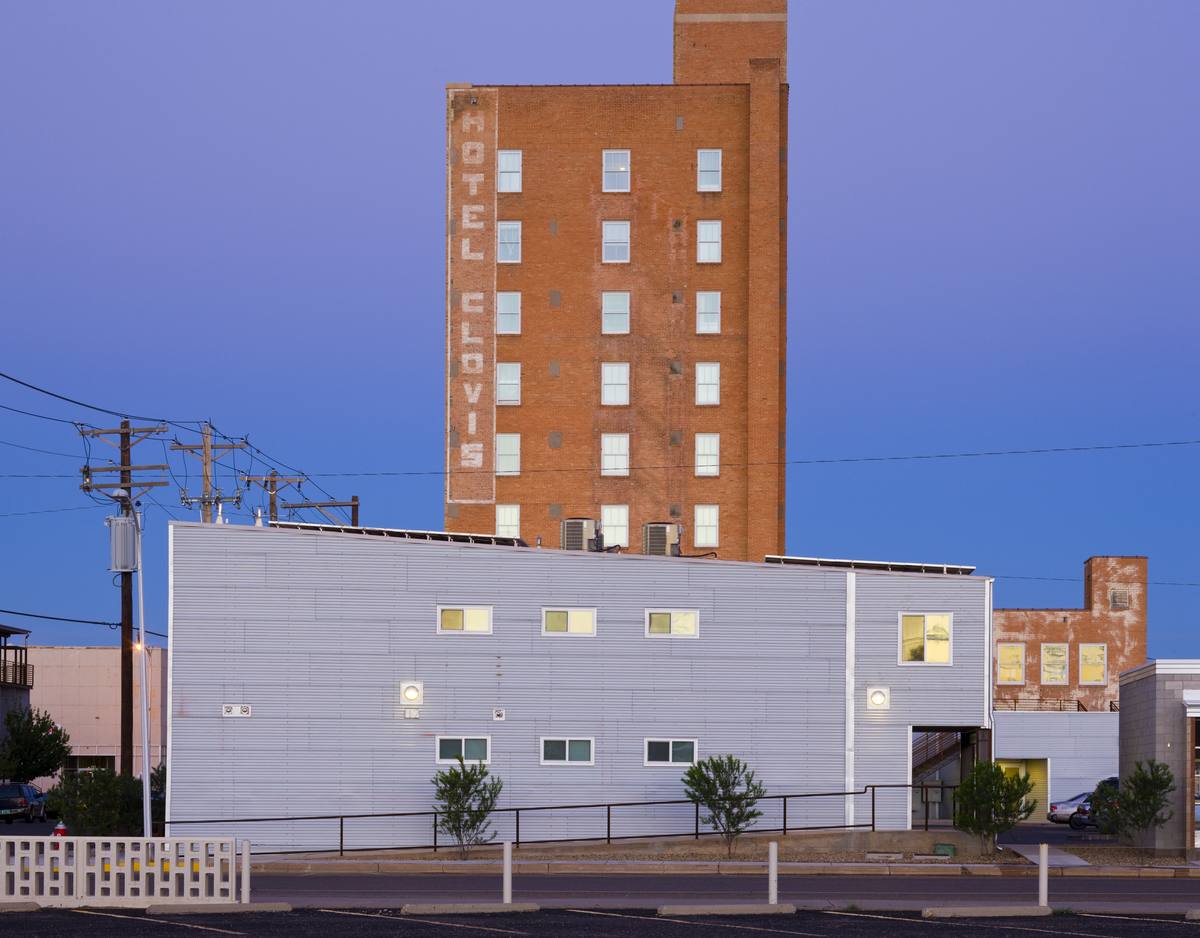 The restored 1929 Hotel Clovis tower at dusk with its rooftop sign lit, downtown Clovis, New Mexico